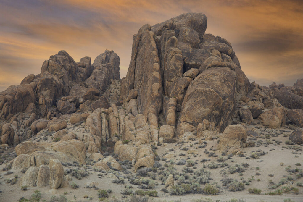 Weathered granite rock formations beneath a colorful sunset sky in the Alabama Hills near Lone Pine, California.