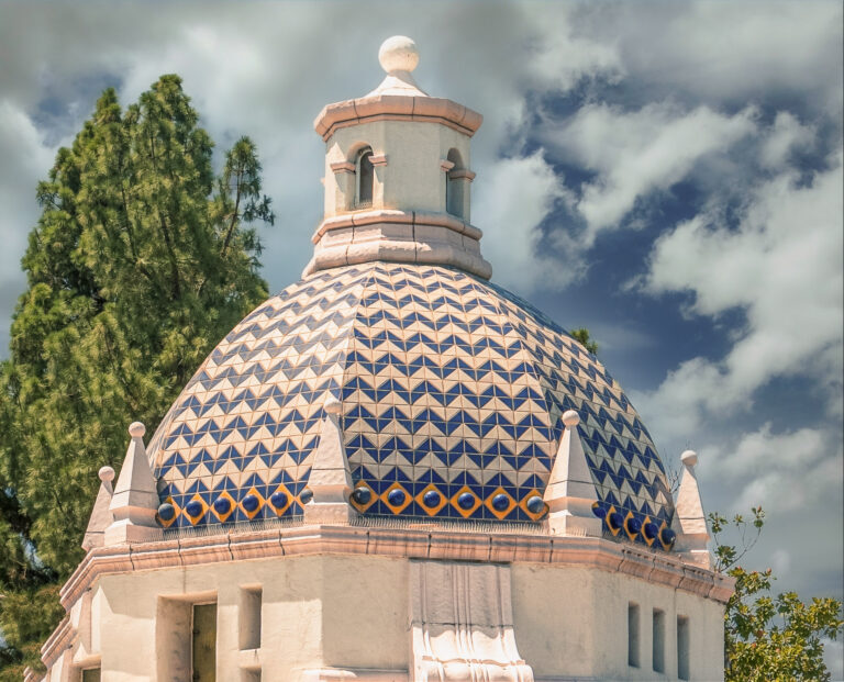 Blue-and-cream tiled dome of the historic Redlands Post Office beneath a cloudy sky.